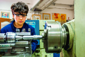 Teen worker using a CNC machine